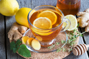 A cup of tea with ginger, lemon, honey and herbs