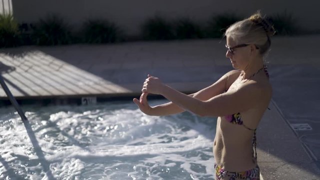 Beautiful Mature Woman Stretching Arms While Standing In A Hot Tub.