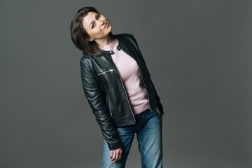 Positive middle aged woman on grey background, copy space