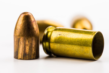 a cartridge case and projectiles lie on a table

