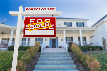Right Facing Foreclosure Sold For Sale Real Estate Sign in Front of House.