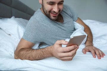 Bachelor man daily routine single lifestyle morning concept browsing smartphone close-up