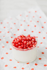Yogurt in a glass with pomegranate seeds