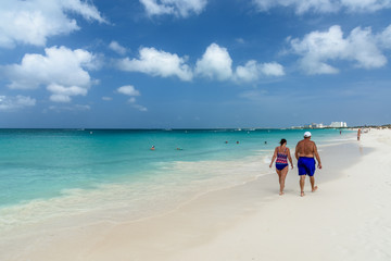 Fototapeta na wymiar Tourists relax along the Eagle Beach of Aruba
