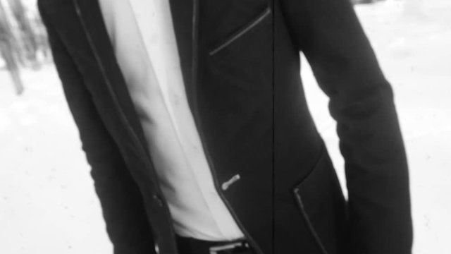 young man posing in a tuxedo in the winter against the white snow,shot in retro style.