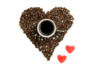 white cup with coffee beans and candy