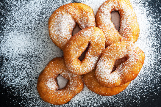 Donuts with powdered sugar on a dark background