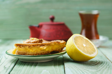 Lemon pie, a glass of tea, on a wooden background
