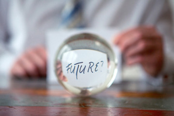 man holding paper with the word Future in front of glass ball