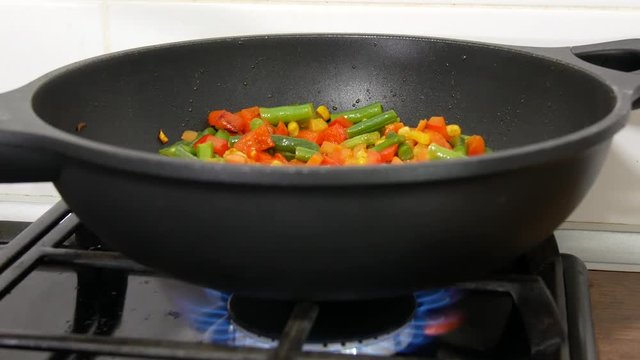 Vegetables in a pan being quenched with vegetable stock (close-up). Frying vegetables in a pan.