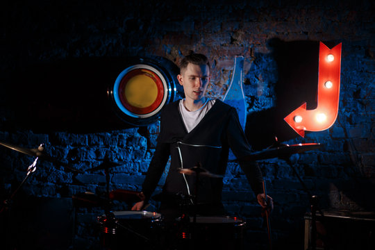 Performance of the rock band. The guitarist plays solo. The bass player plays solo. Drummer. Bass drum. Close-up.