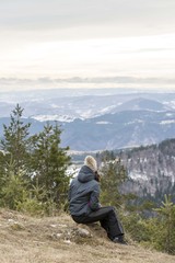 girl taking rest at mountain top and enjoying in beautiful nature 