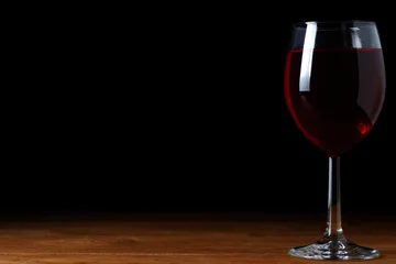 Fotobehang A glass of red wine on a black background, isolate © grek881