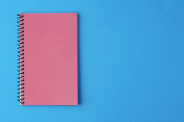 Pink notepad on a blue background, isolate