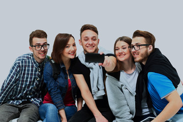 Group of happy young teenager students taking selfie photo isolated on white background.