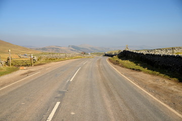 A road snakes through the beautiful Peak District countryside near Castleton, Derbyshire