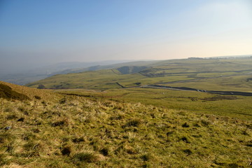 A road snakes through the beautiful Peak District countryside near Castleton, Derbyshire