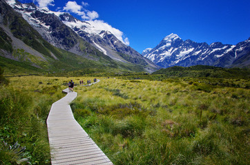 Beautiful landscape of walkway in the nature, mountains in the background. Walking the Hooker Valley Track, Mount Cook, New Zealand. Enjoy the summer. Hiking and walking in the nature. 