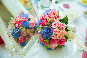 The multi-colored wedding bouquet blossoms in the mirror