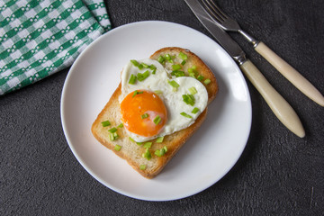 Fried egg in the form of heart on a plate.