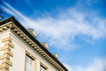 Beautiful real estate property house building on a warm day with summer blue sky and scattered clouds
