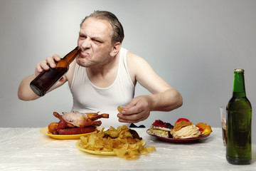 Aging man in a-shirt styling his meal very bad