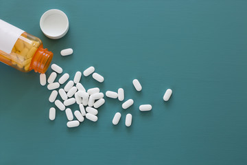 White Pills on a Teal Background - obrazy, fototapety, plakaty
