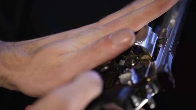 Man put bullet into revolver, spinning barrel, going to play Russian roulette