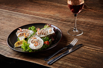 Seafood. Restaurant cuisine, healthy delicatessen food. Oysters, shrimps, octopus in white cream sauce in the shell of oysters.