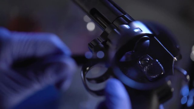 Forensic Expert Watching Serial Number On Revolver, Using Magnifying Glass