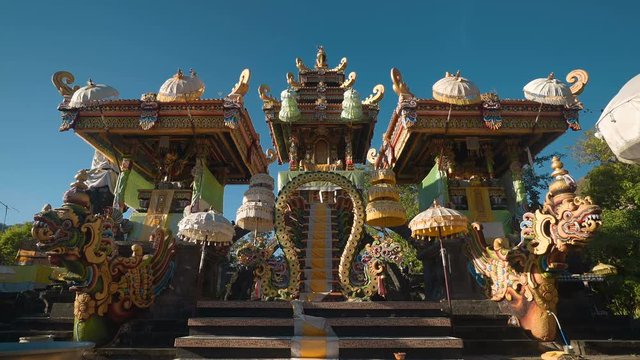 Beautiful balinese temple altar with umbrellas and dragons in Pura Melanting, Pemuteran, Bali - shot on sunny day with blue sky