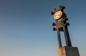 A large outdoor clock viewed against a clear blue sky
