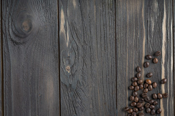 coffee beans/ background of a gray aged wooden countertop and coffee beans in the corner.