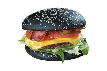 isolated black burger/ Large burger with a black loaf and bacon on a cutting board with a wooden countertop.  Isolated on white background