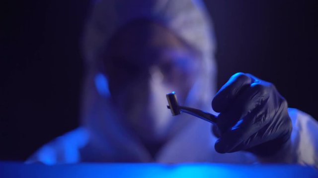 Forensic expert taking bullet at crime scene, personal investigation, night time