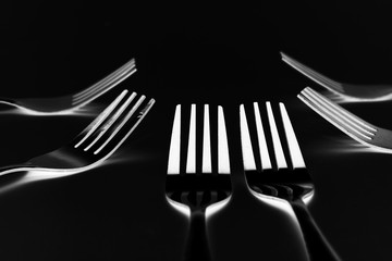 Fork background / A fork, in cutlery or kitchenware, is a tool consisting of a handle with several narrow tines on one end.