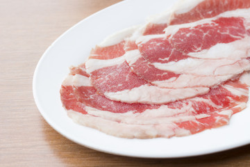 Sliced raw rib eye beef on white dish