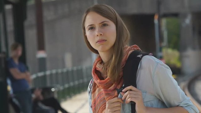 Young woman getting off train recognizing someone she knows.