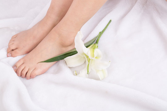 Healthy and elegant well-groomed female feet with the lily flower