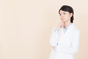 悩む白衣の女性