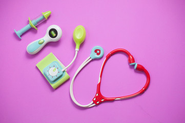 Obraz na płótnie Canvas Top view of medical set toys on pink background