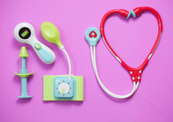 Top view of medical set toys on pink background