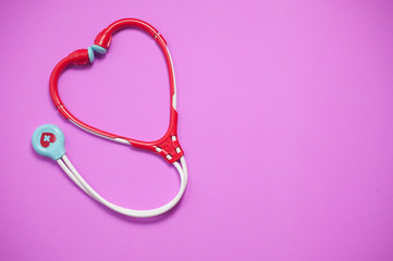 Obraz na płótnie Canvas Top view of Stethoscopes toy on pink background
