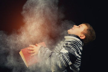 Handsome boy holds in his hands the magic book