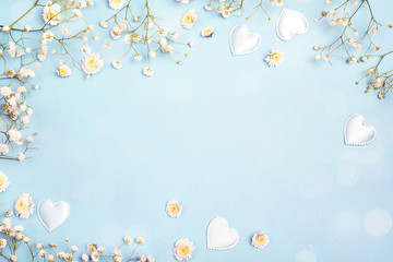 Blue background with gypsophila flowers and hearts. Space for text.