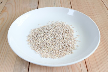 Close up cereal soy bean on white plate with wood plate background.