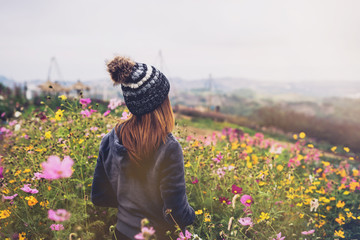 Young woman traveler walking in the flower field
