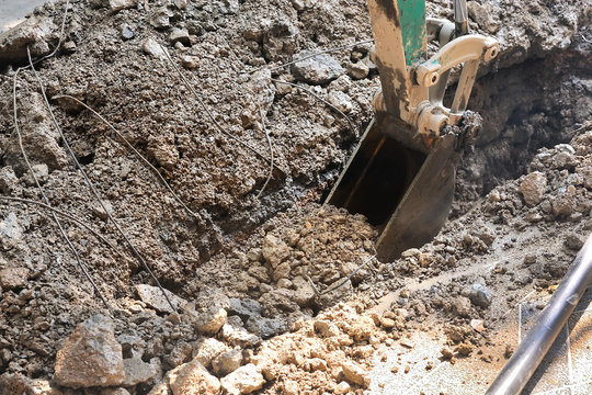 working of scoop of excavator digging while holding the soil.