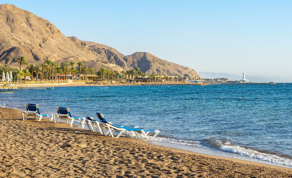 Southern sandy beaches in Eilat - famous resort city with hot sun and clear blue skies, surrounded by mountains and desert scenery landscapes
