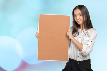 Smiling casual woman holding the empty corkboard